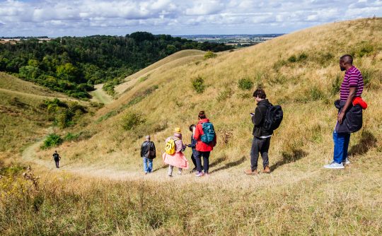 A group of people walk down a hill.