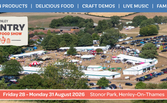 Aerial photo of a showground with large white tents and cars