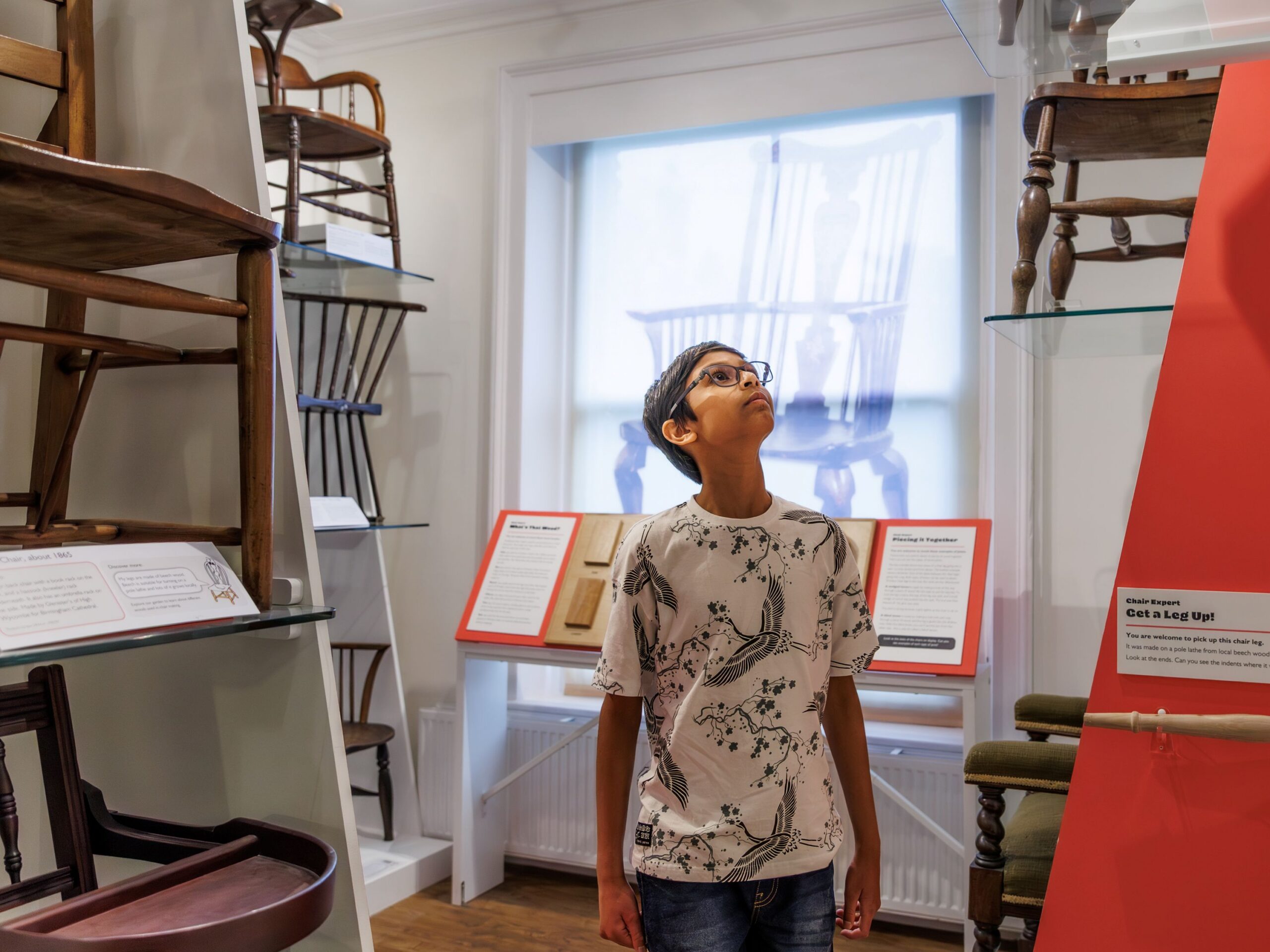 young person exploring a museum gallery of chairs