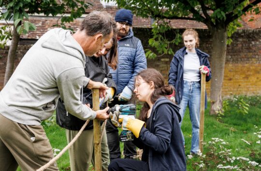 A group of young people working with an adult to install a wildflower circle