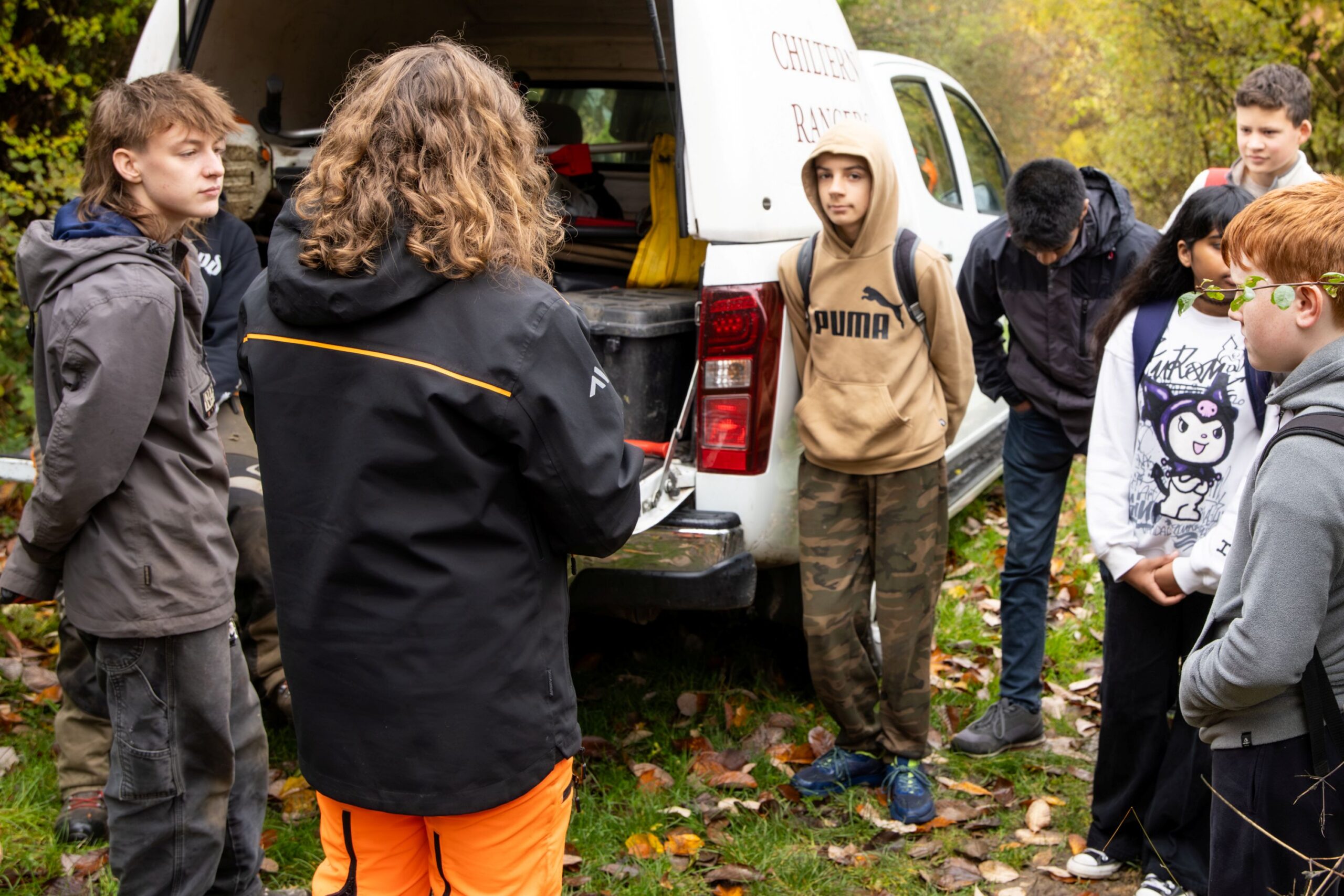 group of young people listening to a briefing session at an outdoor volunteering session