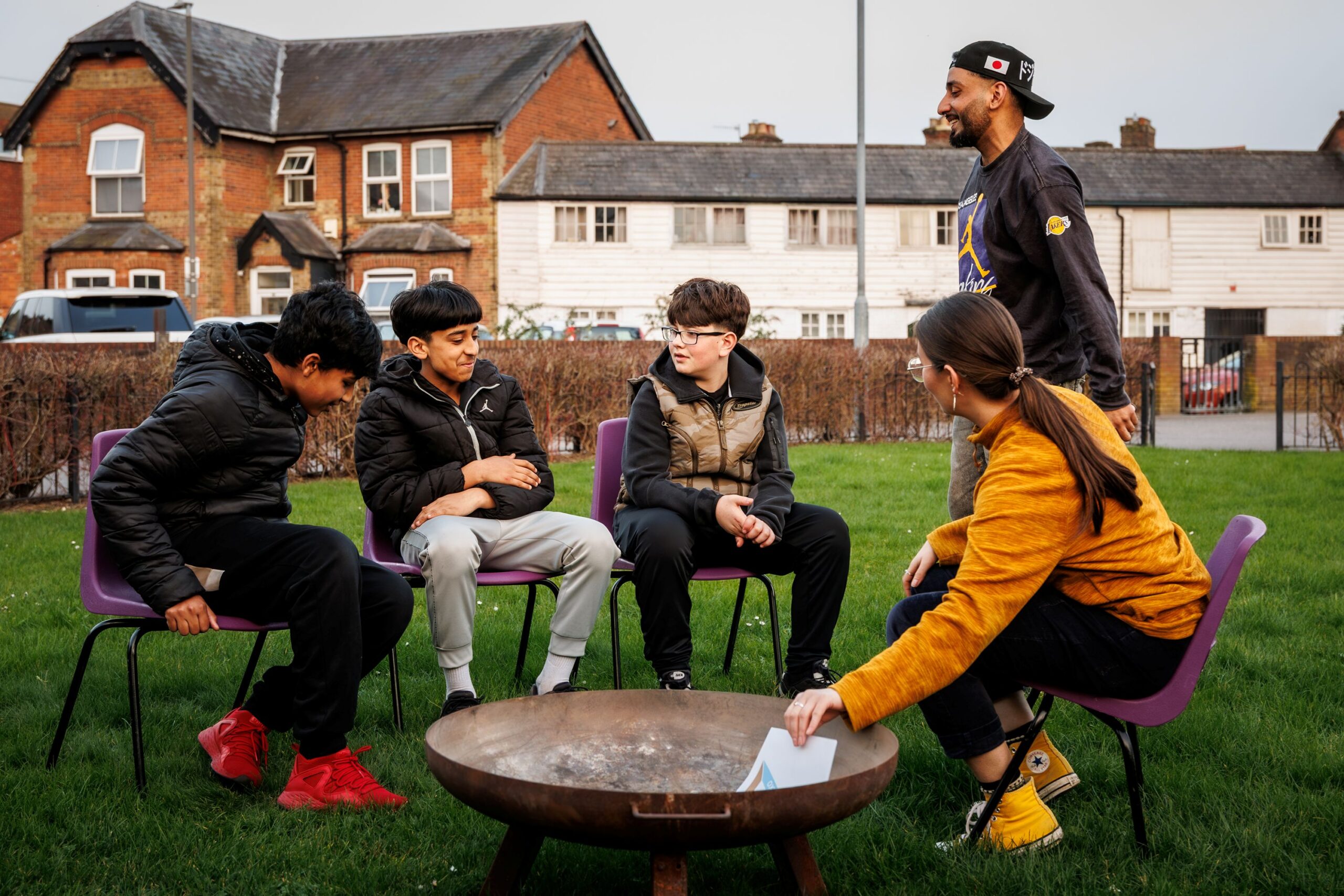 group of young people learning how to light a fire