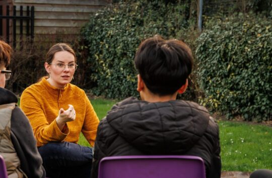 young staff member working with group of young people