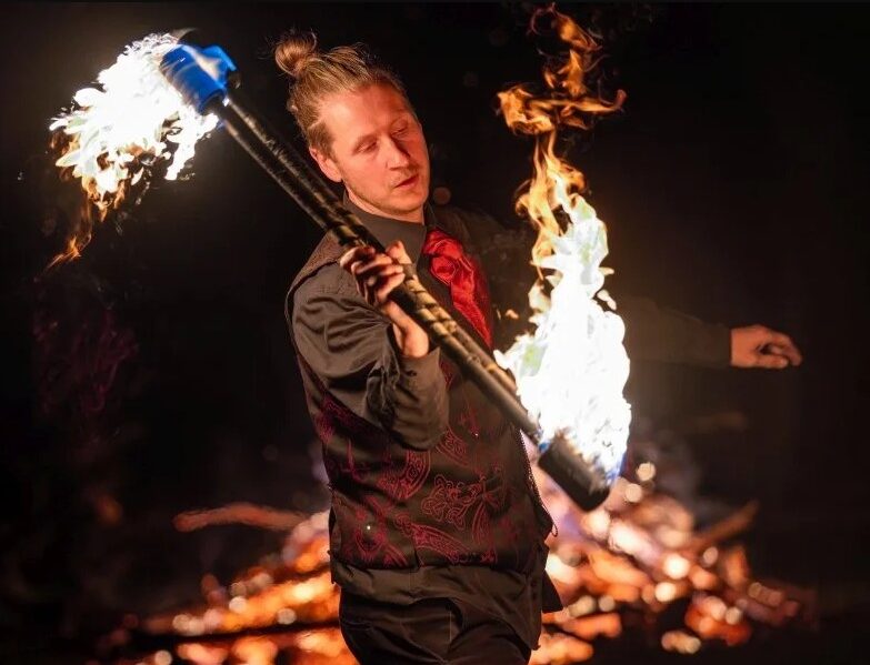 Fire thrower performer set against a night background
